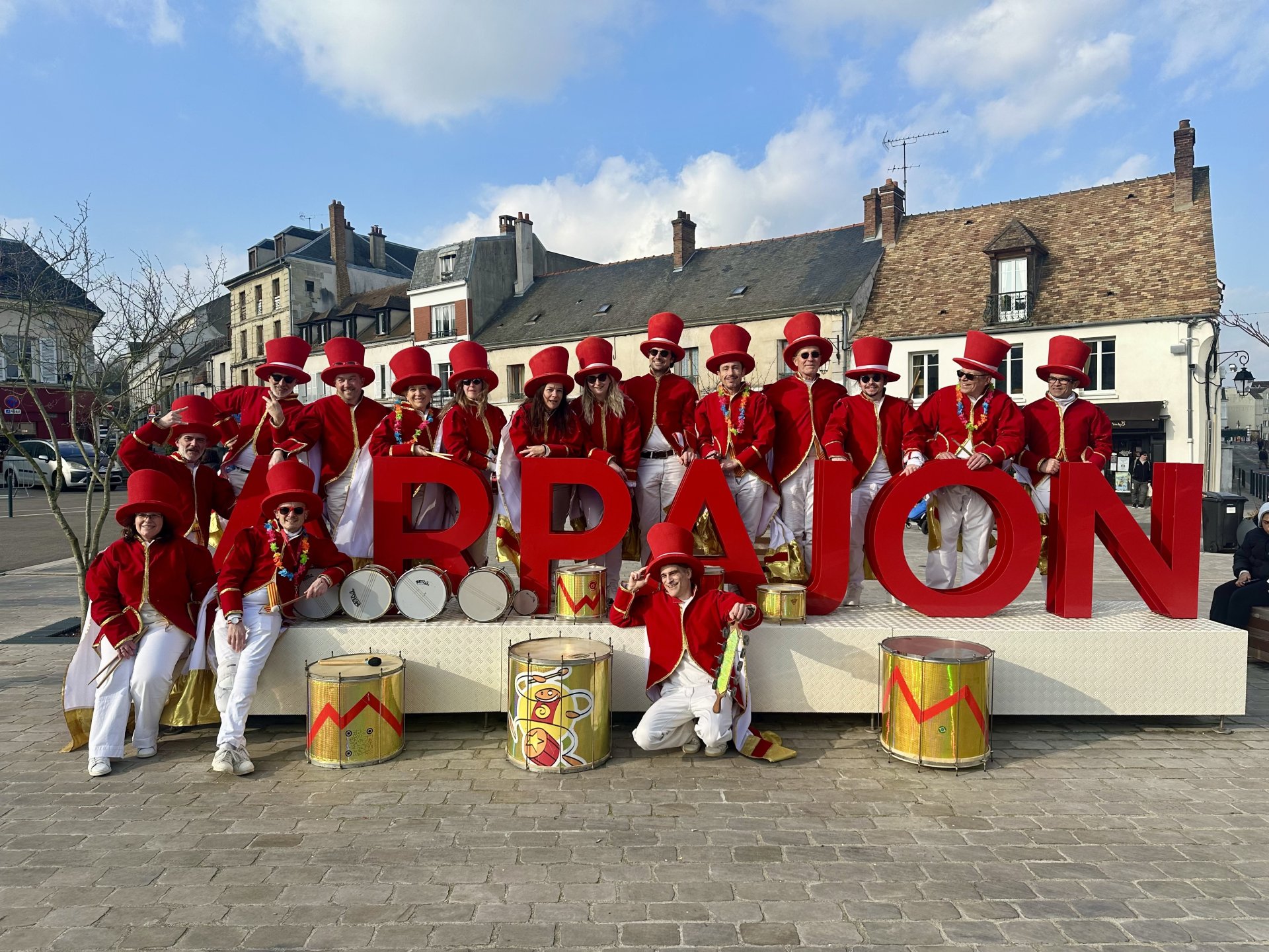 Batucada Les Percuterreux d'la Beauce en défilé à Arpajon, costumes rouge et or avec percussions