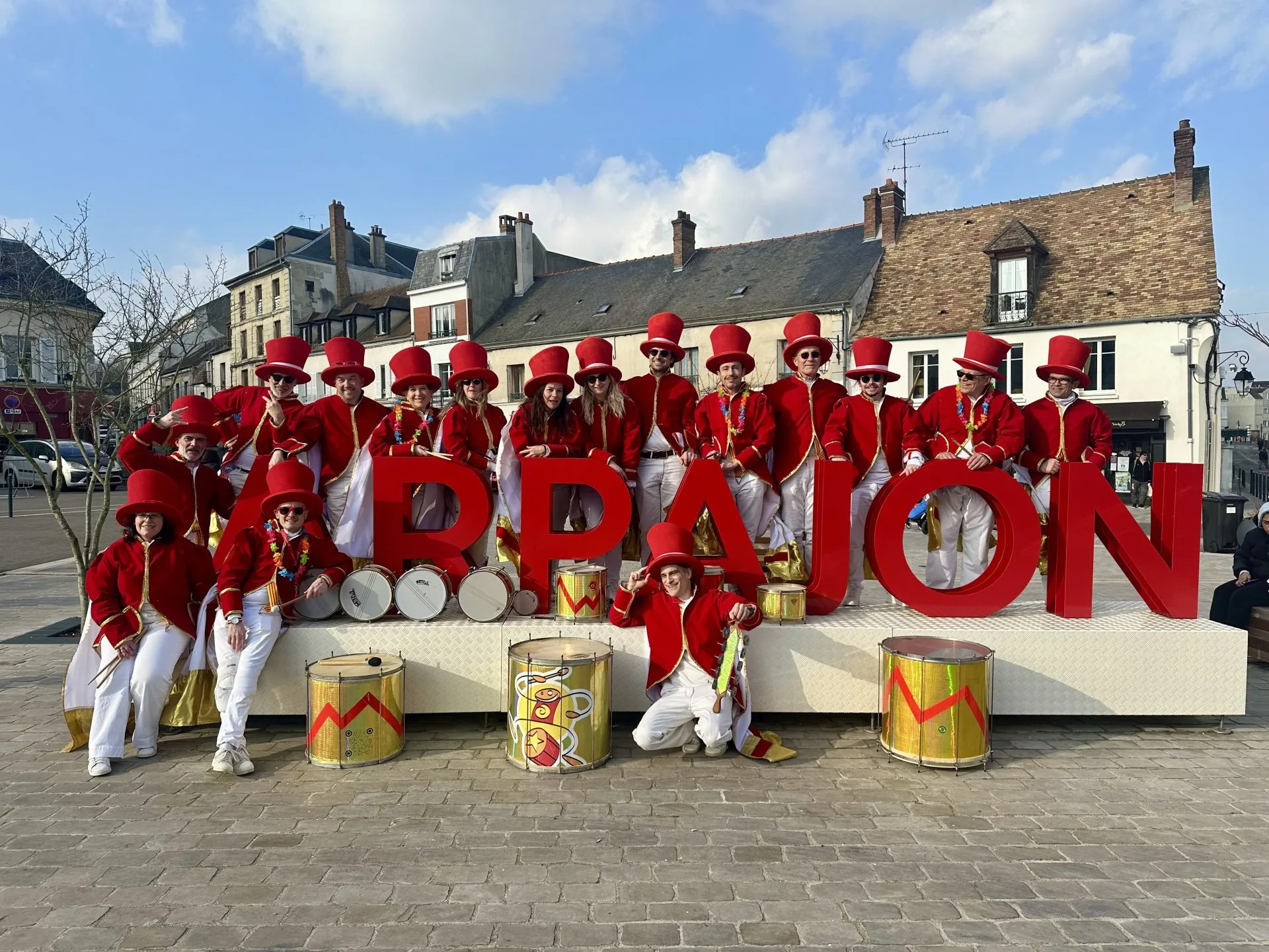 Batucada Les Percuterreux d'la Beauce en défilé à Arpajon, costumes rouge et or avec percussions